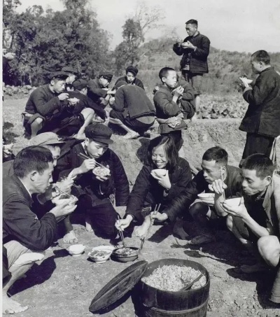 1958年，四川<em>红光</em>公社农田里，一群社员正在地头吃中午饭时的情景|